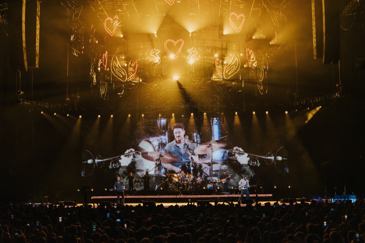 Mumford and Sons in Glasgow with golden neon heart graphics above the stage
